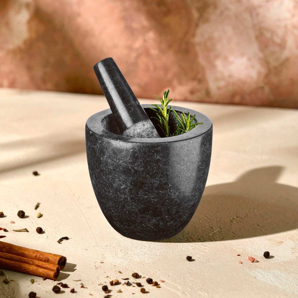 Norse speckled charcoal granite mortar and pestle set with rosemary inside for grinding herbs and spices