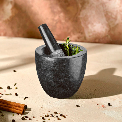 Norse speckled charcoal granite mortar and pestle set with rosemary inside for grinding herbs and spices