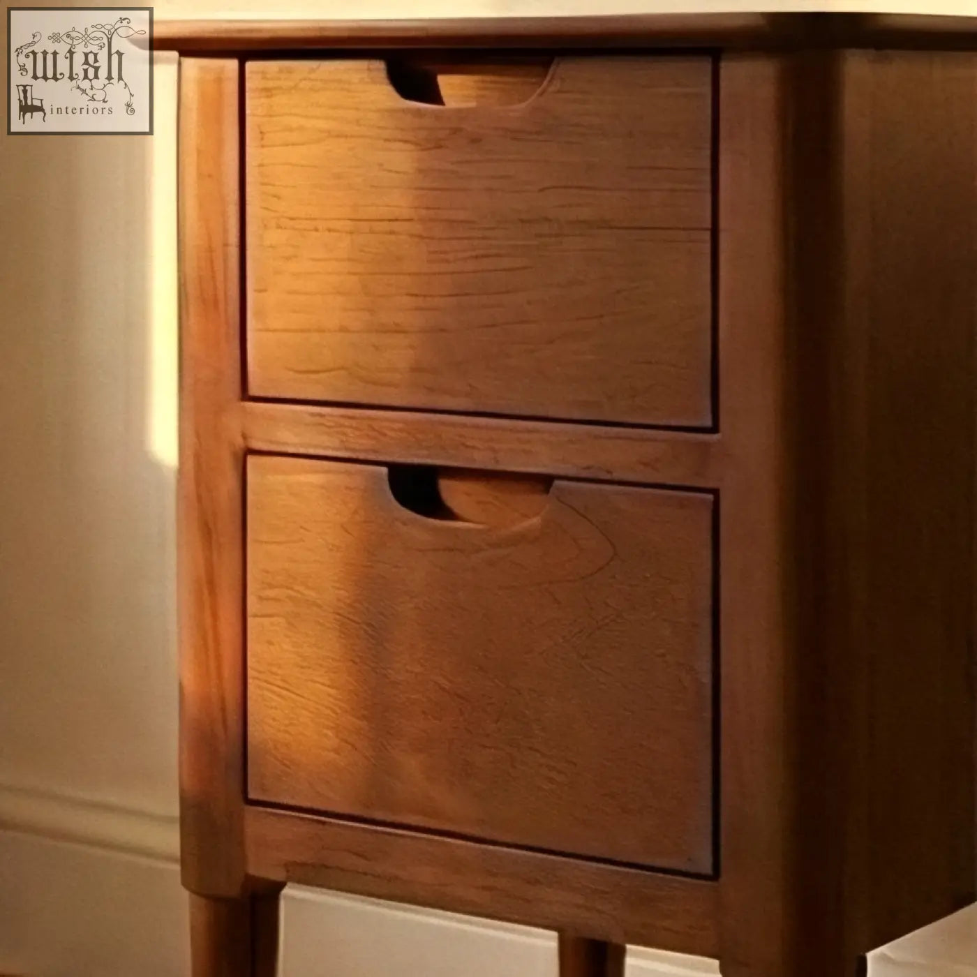 A warm-toned norway wooden bedside table with two drawers and simple cutout handles from wooden furniture collection
