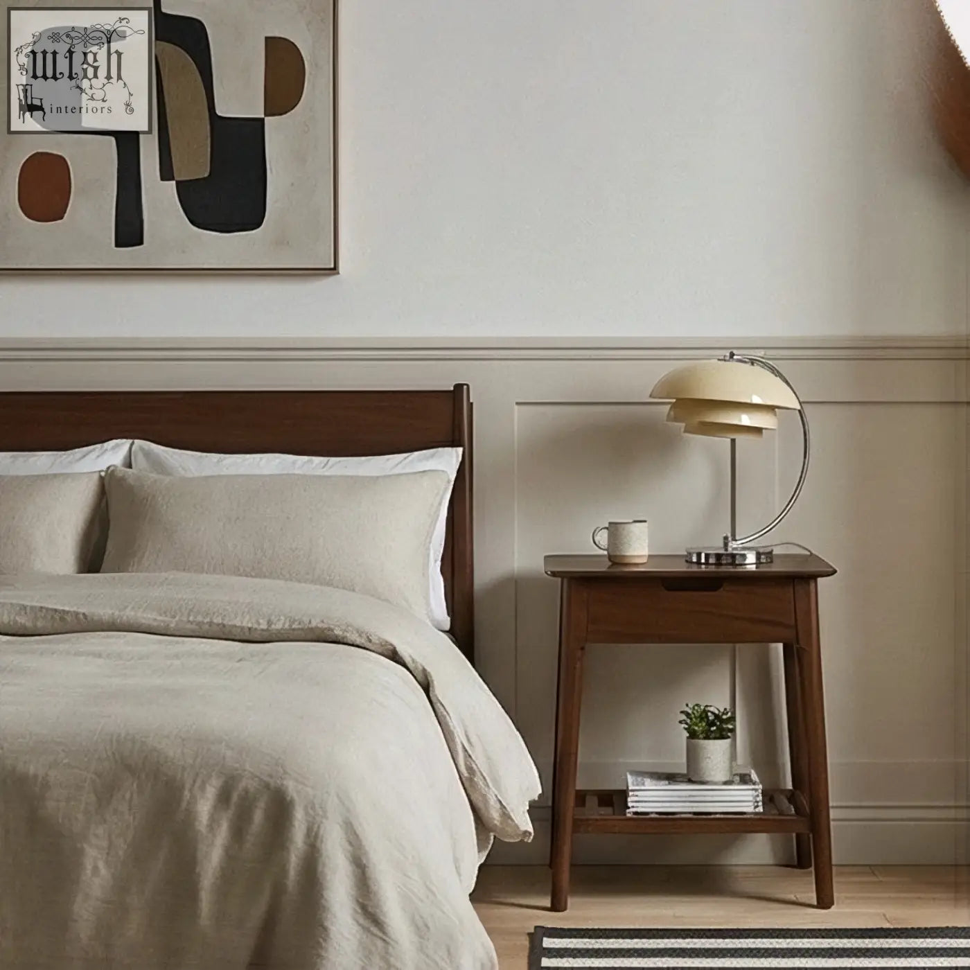 Cream-colored layered shade table lamp with curved metallic base on norway walnut bedside table with solid white cedar accents