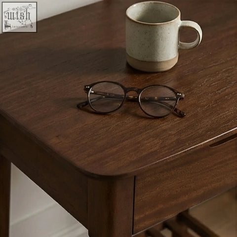 A pair of tortoiseshell reading glasses on a dark wood norway walnut bedside table with solid white cedar accents