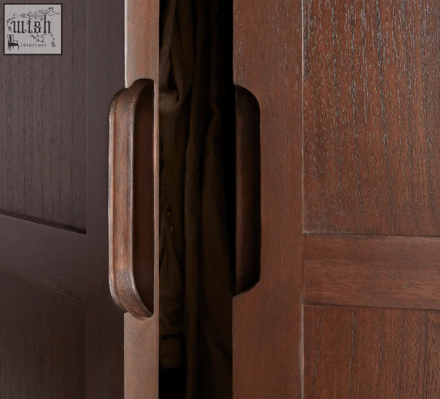 Dark brown wooden door handle with smooth rounded rectangular design on norway walnut wardrobe with white cedar wood accents