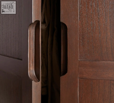 Dark brown wooden door handle with smooth rounded rectangular design on norway walnut wardrobe with white cedar wood accents