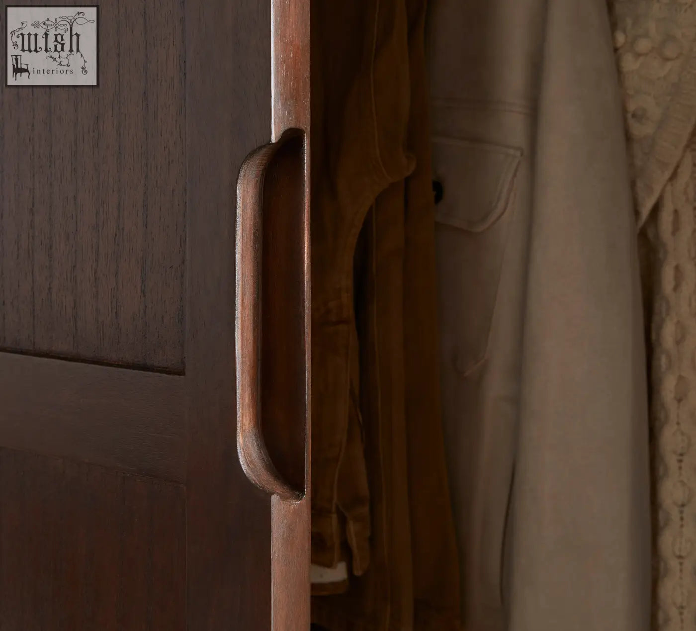 Dark wood cabinet handle with smooth rounded rectangular design on norway walnut wardrobe featuring white cedar wood accents