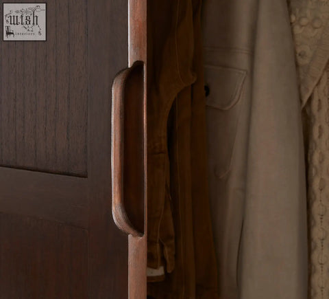 Dark wood cabinet handle with smooth rounded rectangular design on norway walnut wardrobe featuring white cedar wood accents