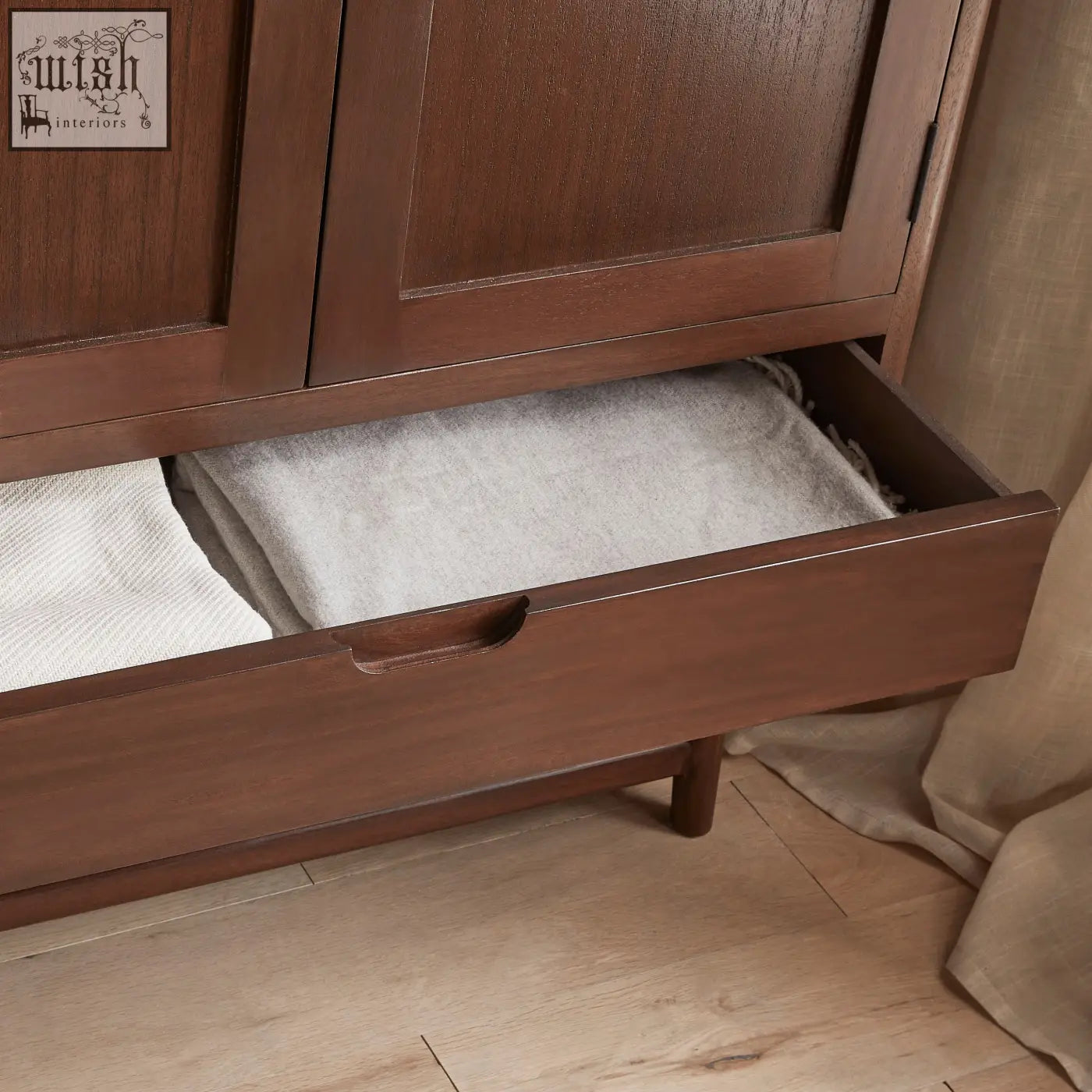 A sleek dark brown norway walnut wardrobe drawer with minimalist handle and white cedar wood folded white towels inside