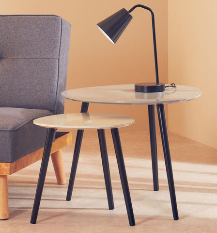 Modern black metal lamp with sleek conical shade beside nostra set of 2 triangular nesting tables in minimalist design