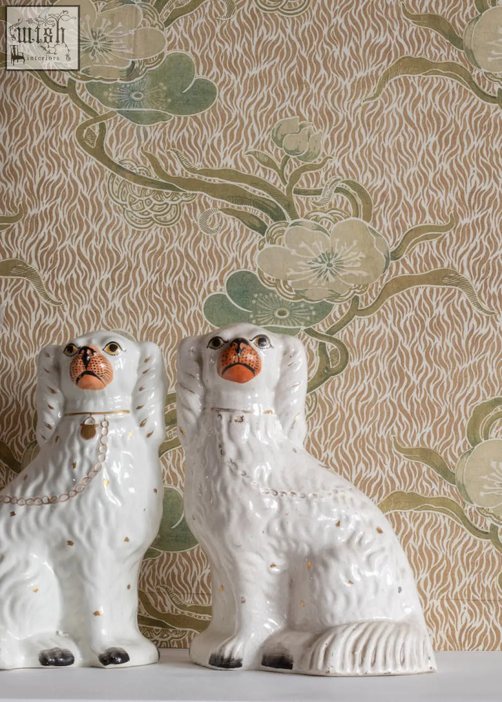 White ceramic staffordshire spaniel figurines with orange brown snouts and gold details for nouveau blossom gold wallpaper