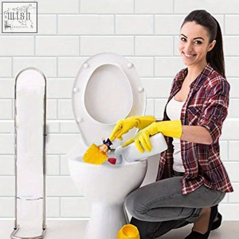 White ceramic toilet with raised seat and lid with rounded edges next to novelty trump-inspired toilet brush set for bathroom cleaning