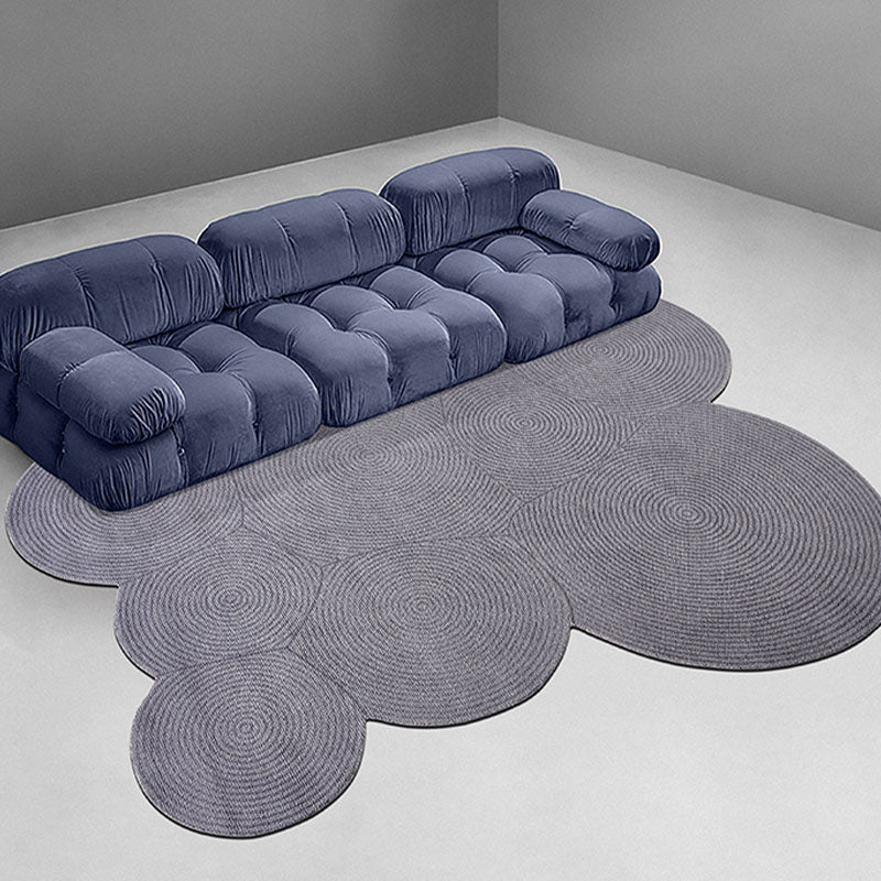 Deep blue velvet sofa with tufted cushions shown alongside nulaa fractal wool rug in various shapes available