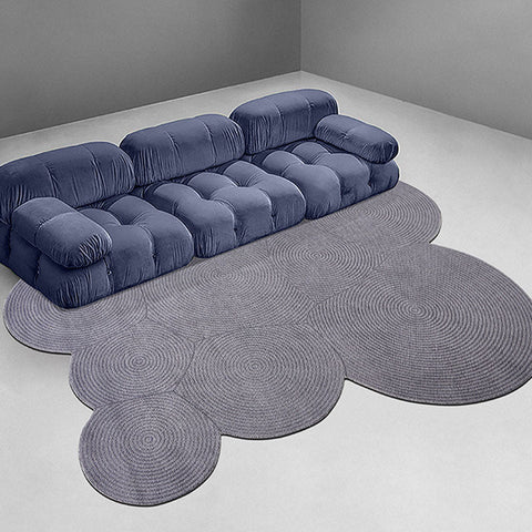 Deep blue velvet sofa with tufted cushions shown alongside nulaa fractal wool rug in various shapes available