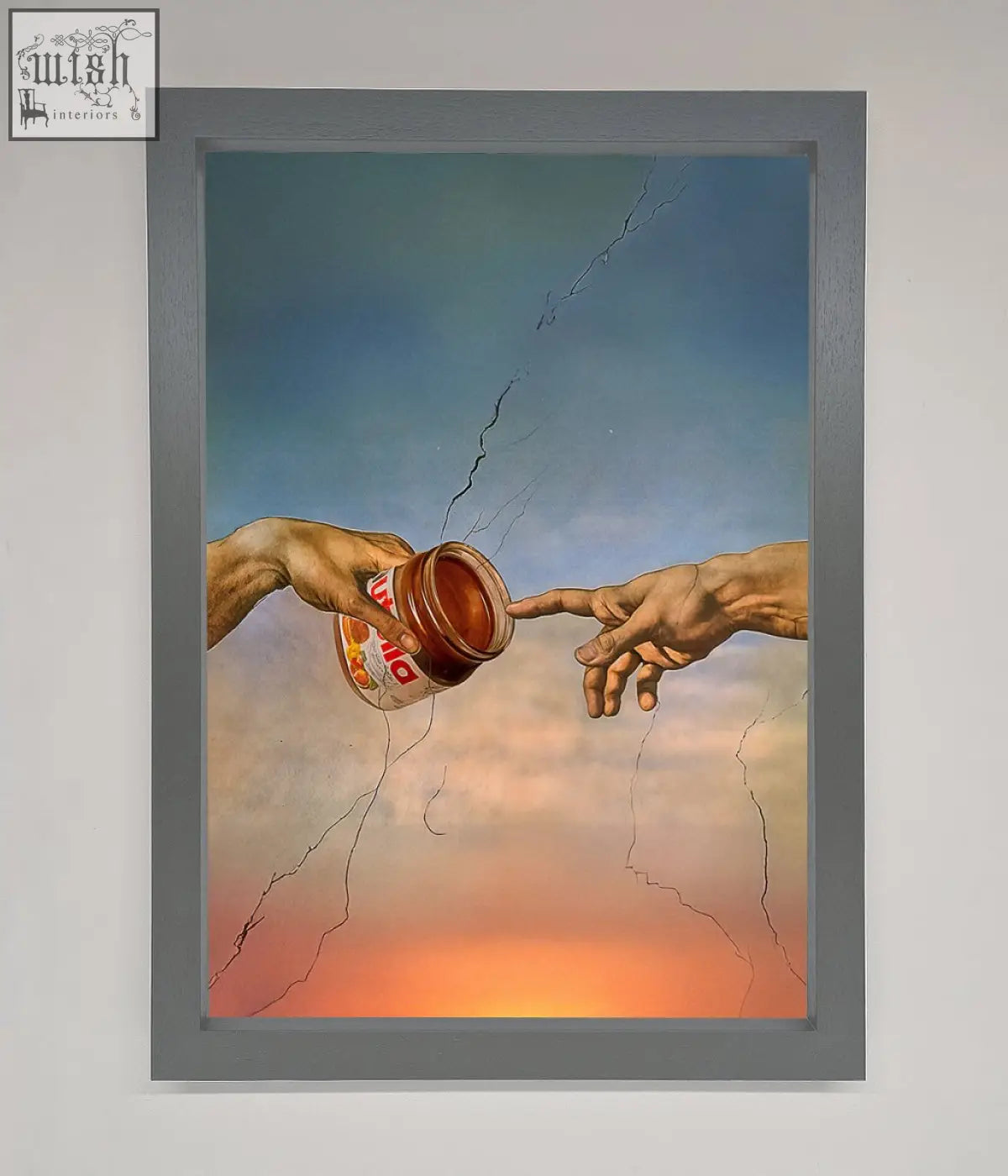 A framed poster showing two hands reaching to touch with one holding a jar of nutella against a cracked sky in a creation framed poster design