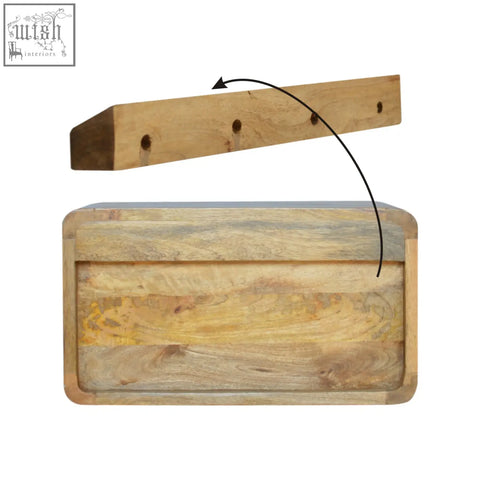 Natural wood butcher block with rustic multi-toned finish and four holes for hanging on oak-ish drawer floating bedside