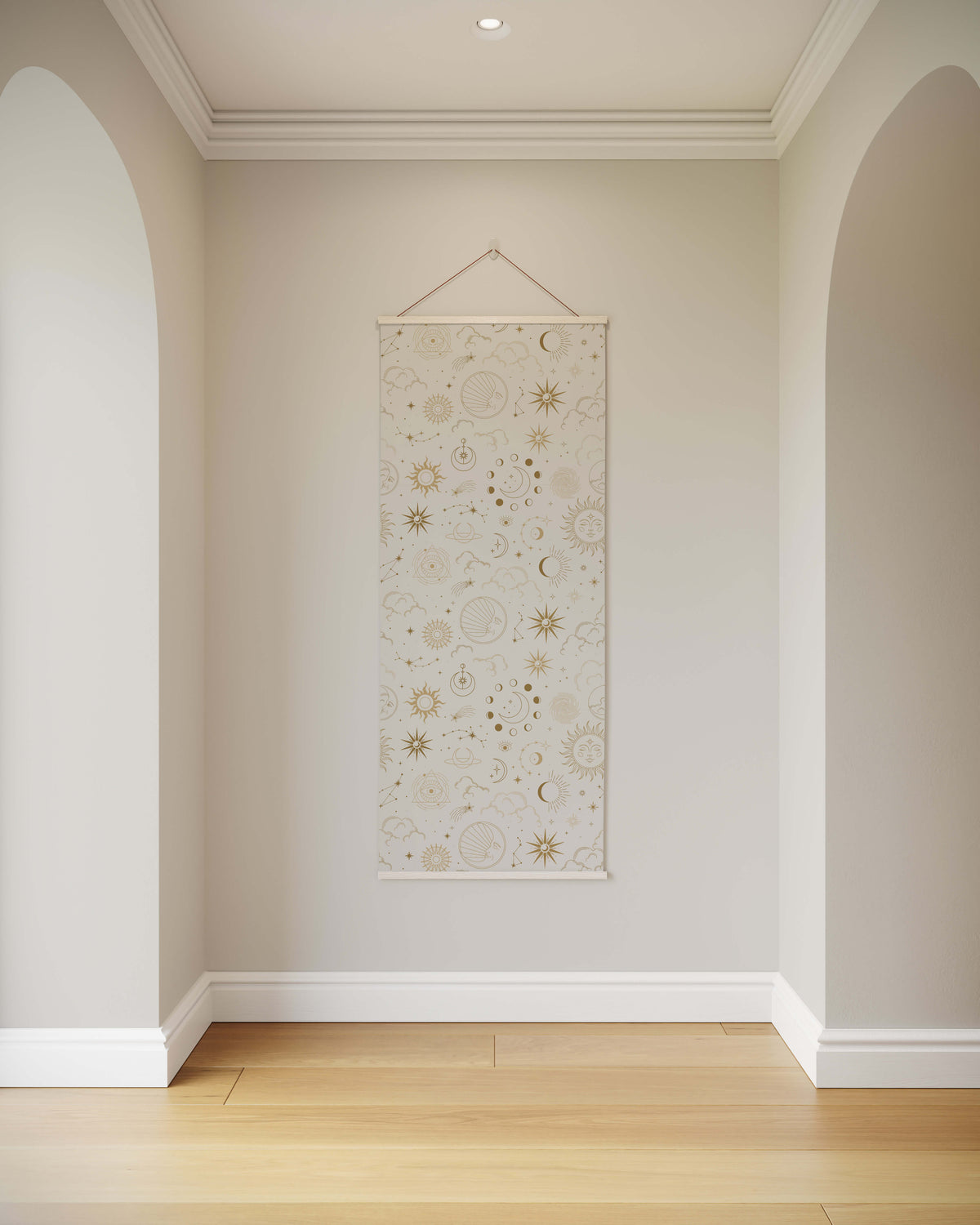 A cream-colored occult pattern tapestry with gold and beige suns moons and stars hanging on a wall