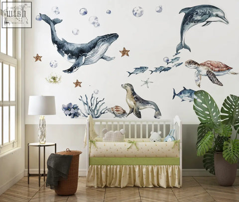 Ocean animals wall decal featuring a whale with watercolor gray blue detailing and playful underwater creatures for kids rooms