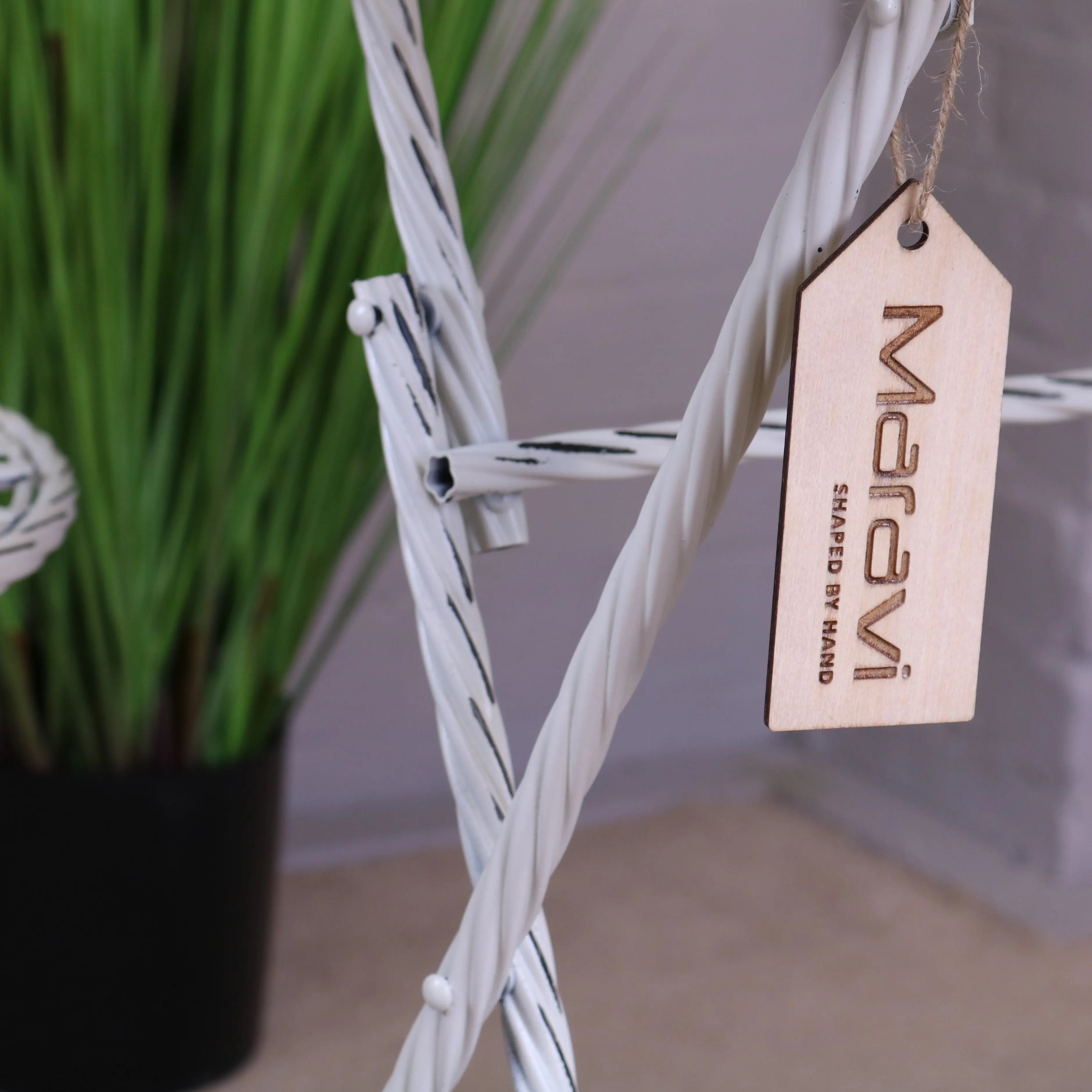 White twisted rope plant stand with wooden maravi shaped by hand tag next to odal 3 piece oval garden table and chairs