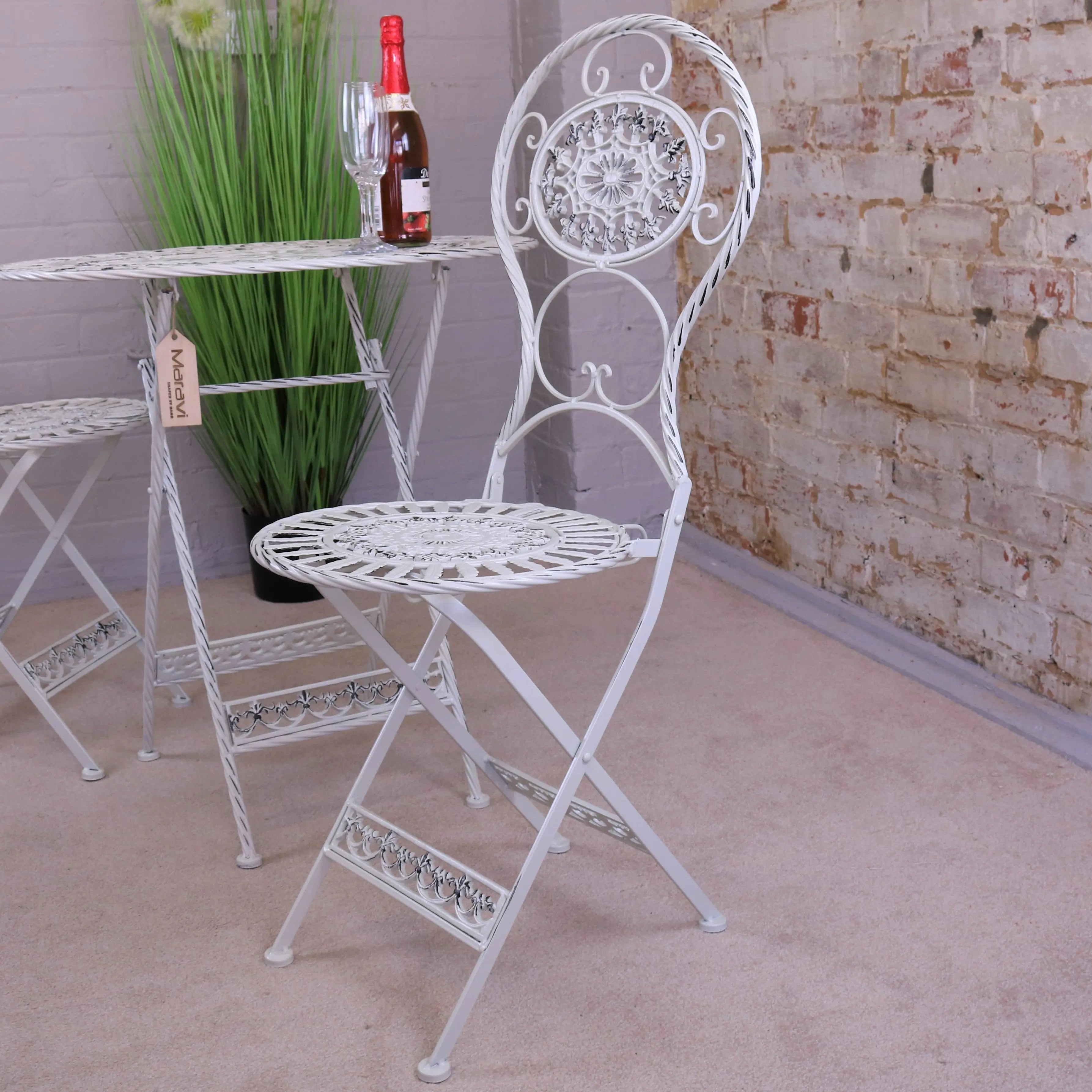 White wrought iron folding chair with ornate scrollwork from odal 3 piece oval garden table and chairs set
