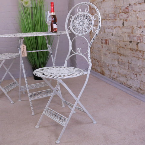 White wrought iron folding chair with ornate scrollwork from odal 3 piece oval garden table and chairs set