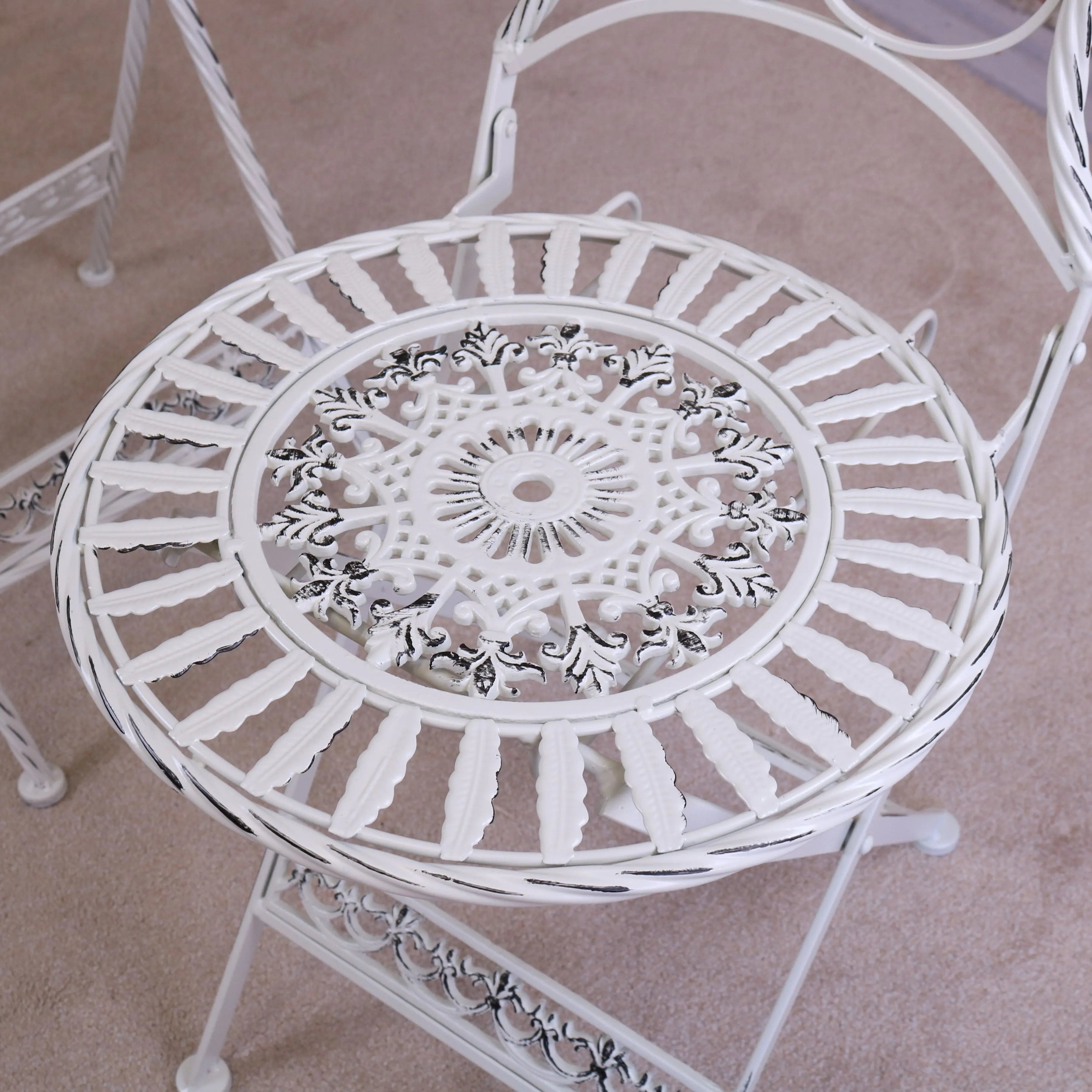 White wrought iron patio chair with intricate floral scrollwork from odal 3 piece oval garden table set