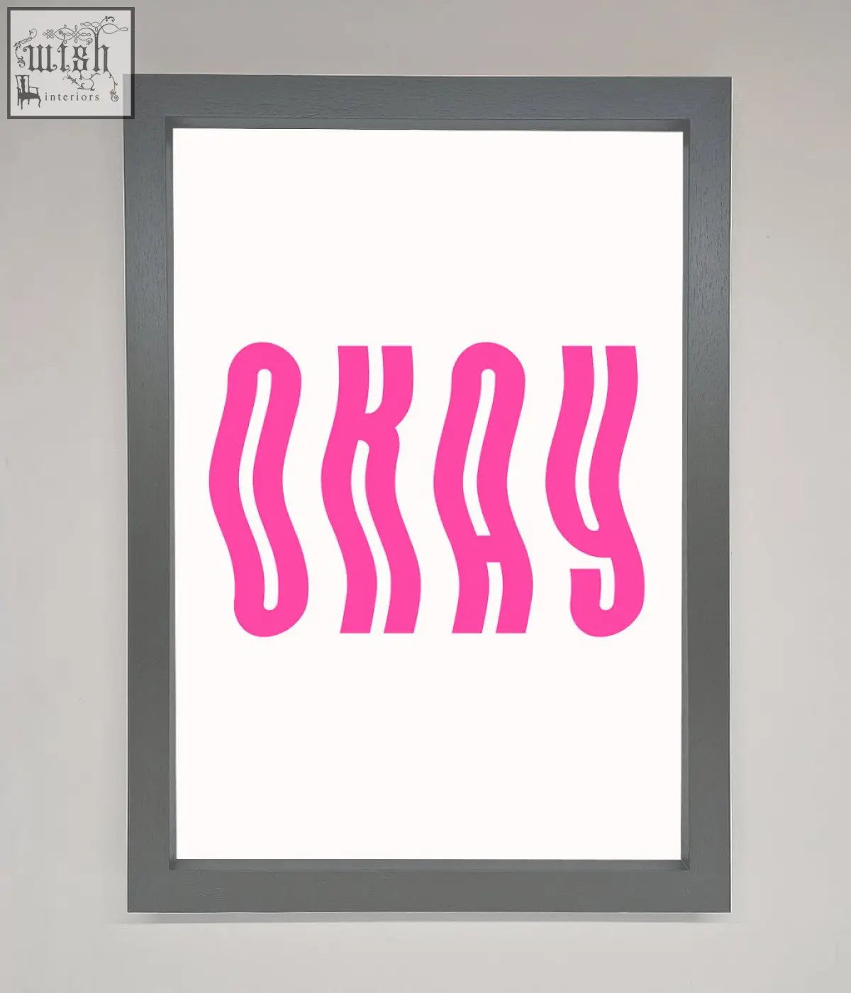 A framed poster with bold wavy pink okay lettering on a white background for stylish wall decor