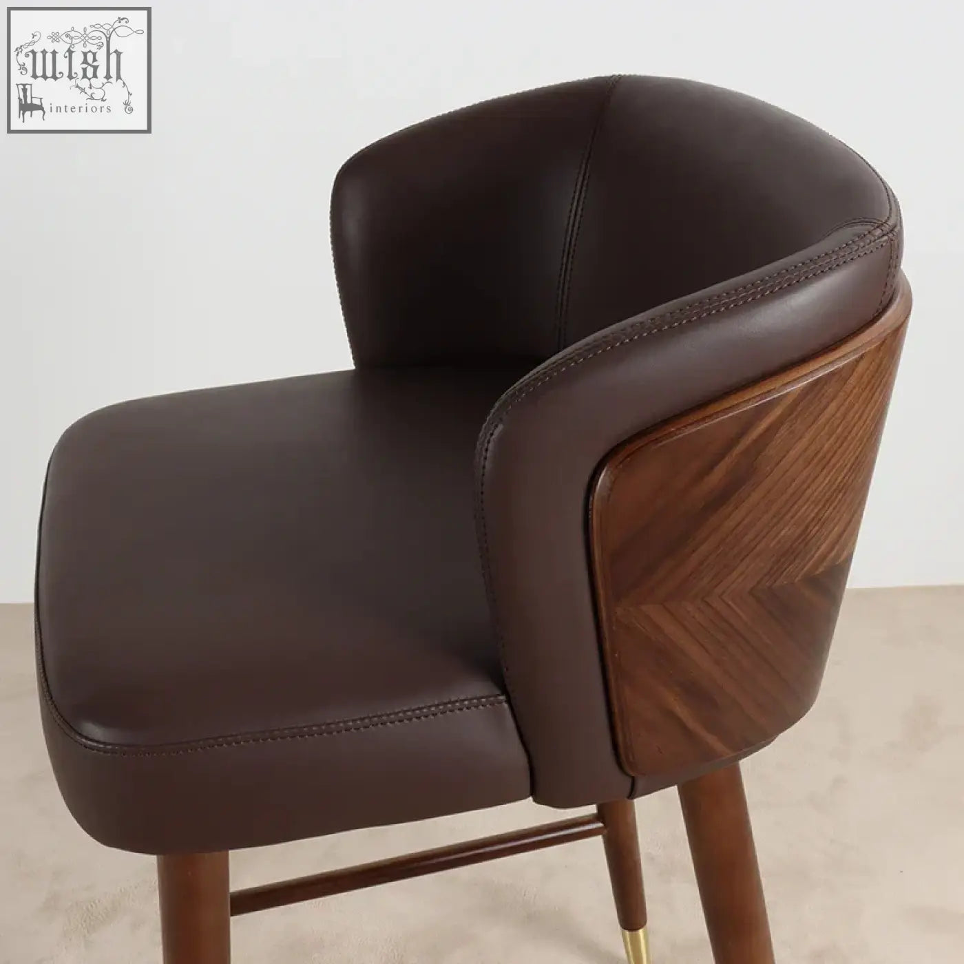 Okazaki bar stool with brown leather upholstered seat, curved backrest, and tapered wooden legs for stylish seating