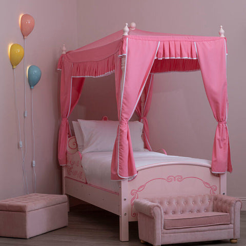 Pink canopy bed with decorative scrollwork and matching pink curtains with white trim for kids pink balloon room decor