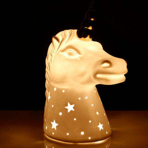 Cream-colored ceramic night light shaped like a unicorn with gold horn and star and dot cutouts perfect for kids room