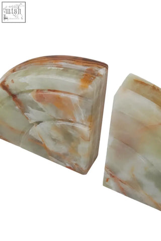 A pair of elegant semi-translucent two onyx bookends in creamy white and warm amber hues from the oleena set