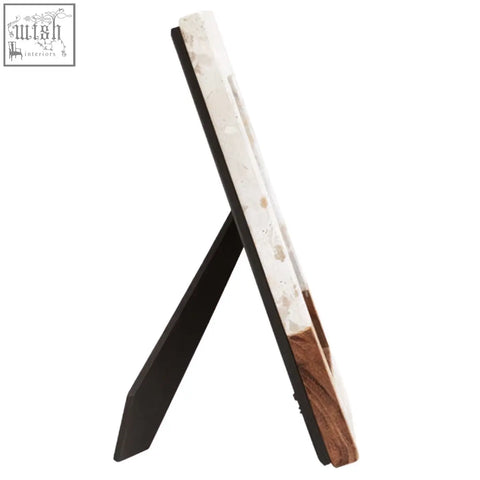 A sleek black and white marble large photo frame with wood accent base standing on easel stand for display