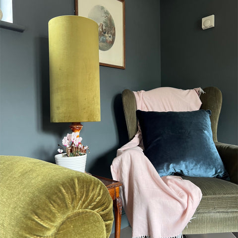 A tall mustard yellow velvet lampshade with wooden base similar to olive green velvet cylinder lampshade style