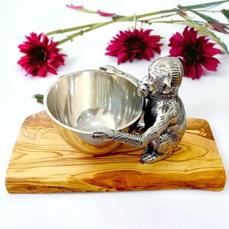 Silver monkey-shaped serving bowl with detailed fur and olive wood base holding a round reflective interior
