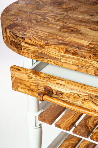 Olive wood butcher block counter island with curved edge and matching drawer front in warm golden-brown tones