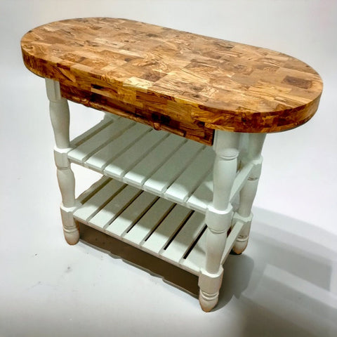Oval-shaped olive wood butcher block kitchen island with patchwork top and white painted legs and shelves