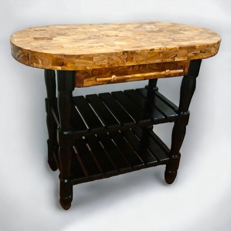 Oval-shaped olive wood butcher block kitchen island with mosaic top and dark stained legs and shelves