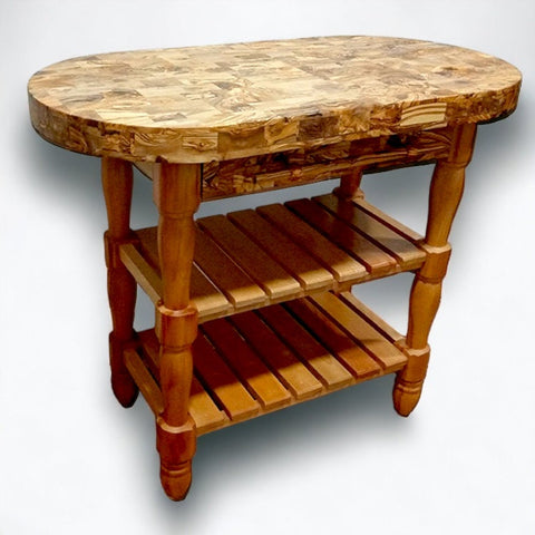 Rustic olive wood butcher block counter island with oval top and turned legs featuring two open shelves