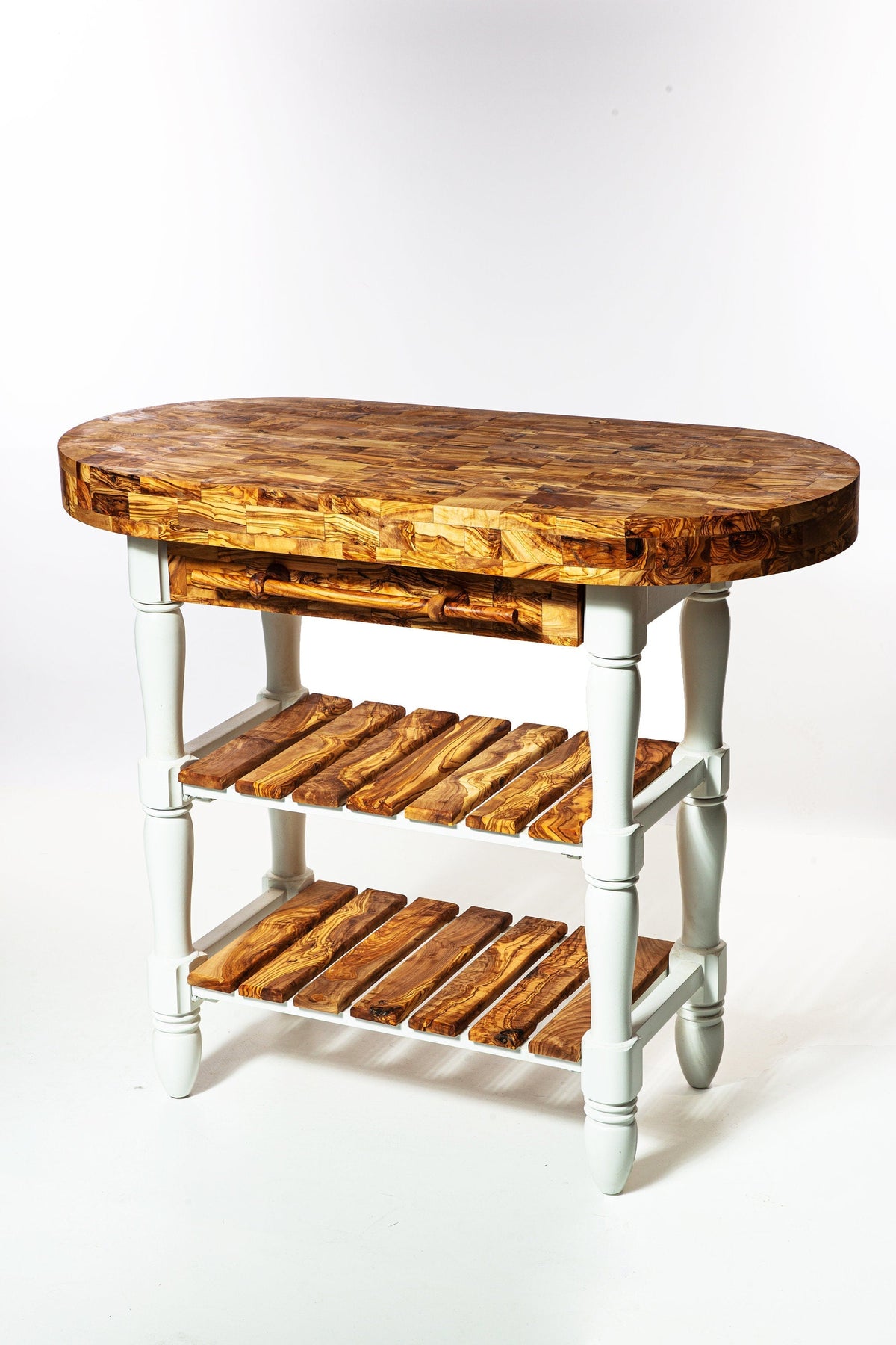 Oval-shaped olive wood butcher block table with white painted legs and shelves for kitchen island storage