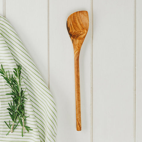 A rustic olive wood corner spoon with a smooth natural finish and unique swirling grain pattern