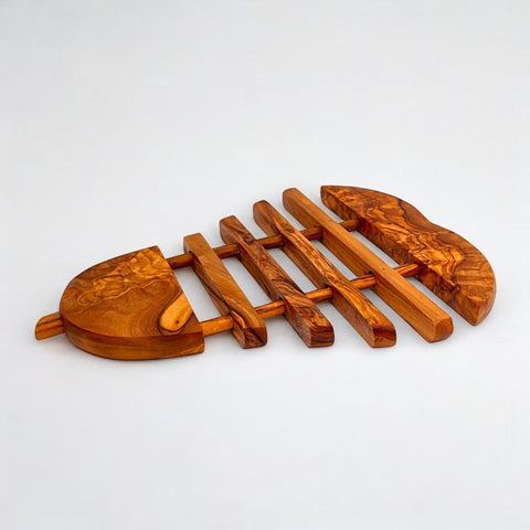 Handcrafted olive wood pear pan coaster shaped like a fish with natural grain and warm amber tones for kitchen use