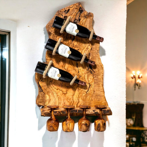 Natural olive wood rustic bottle holder with two dark bottles and four carved wooden wine glasses below