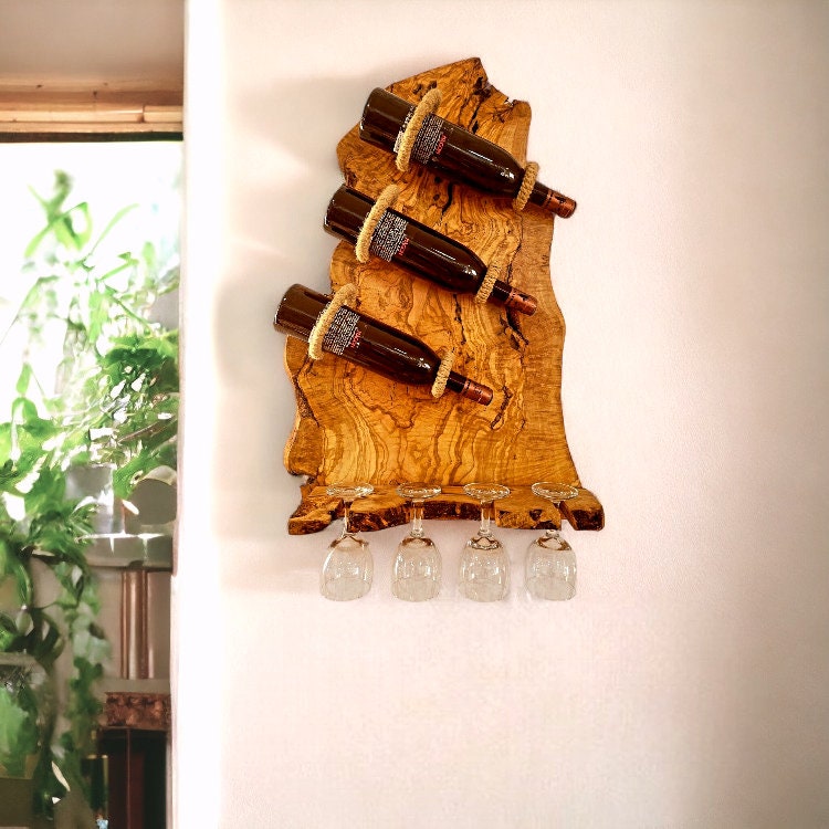 Olive wood rustic bottle holder with three dark wine bottles secured by rope and four clear stemmed glasses hanging below