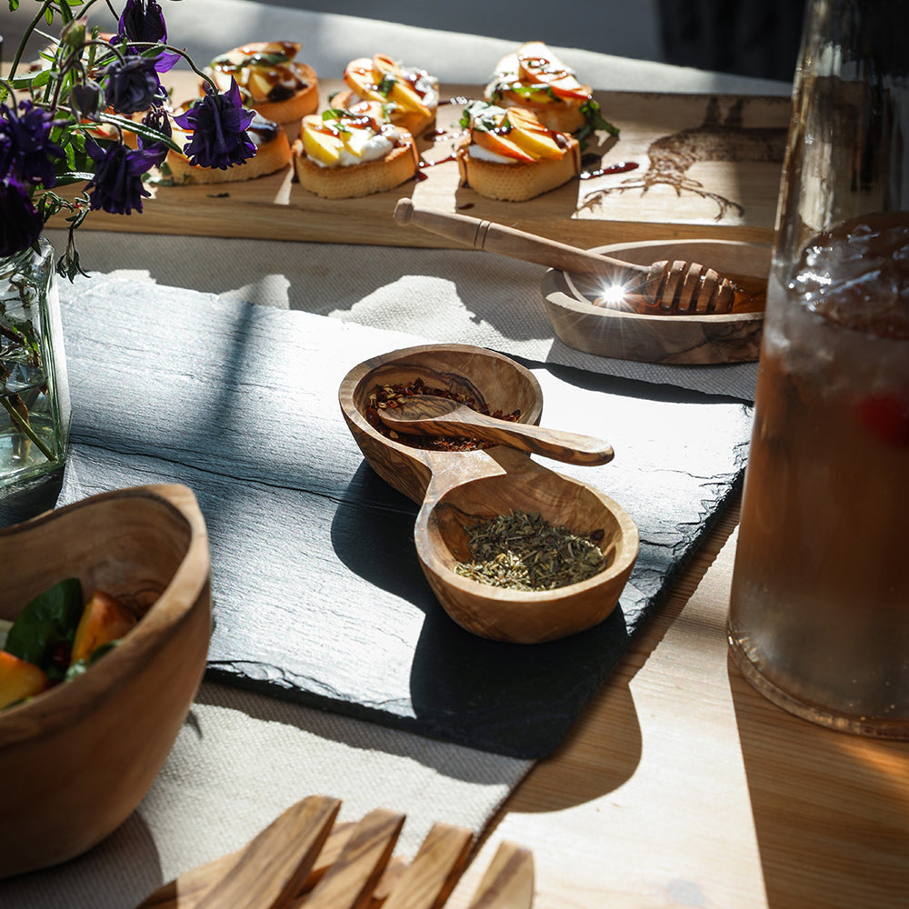 Hand carved olive wood spice holder with two bowls, one with dried herbs and a wooden spoon for sugar jam mustard