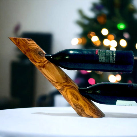 A sleek v-shaped olive wood bottle holder with natural grain and warm golden brown finish ideal for wine bottles