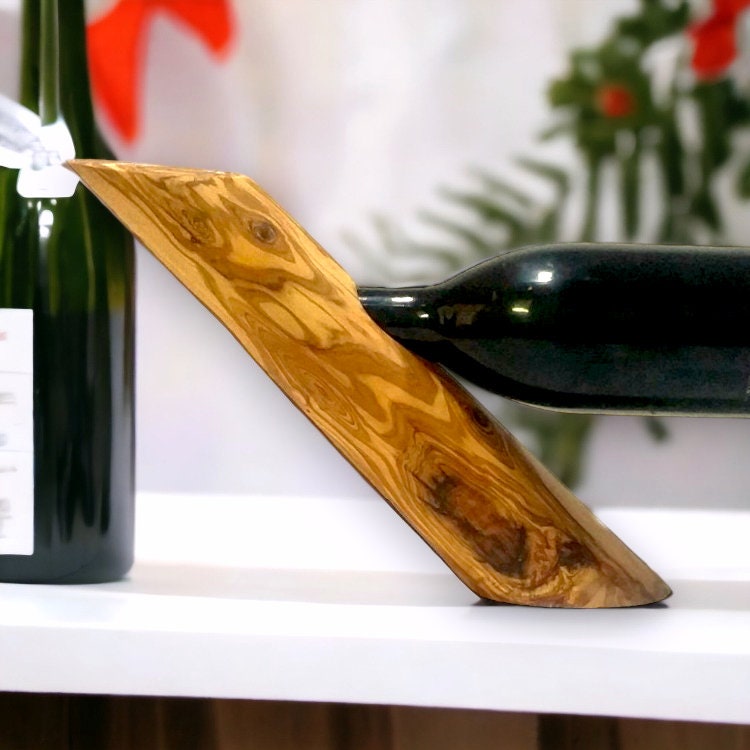 A sleek olive wood bottle holder with smooth grain and warm golden brown tones perfect as a wine barware gift