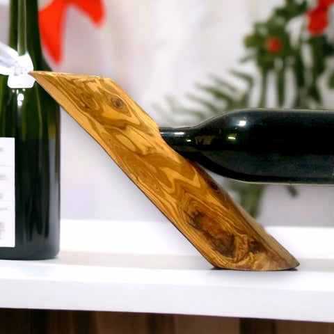 A sleek olive wood bottle holder with smooth grain and warm golden brown tones perfect as a wine barware gift