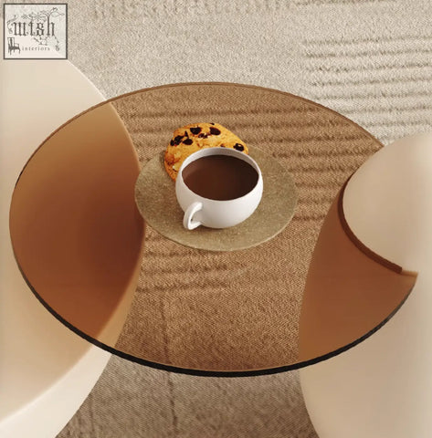 White ceramic mug with coffee on gold coaster beside cookie on oliver nesting coffee table white