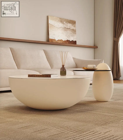Cream-colored egg-shaped nesting coffee table with sleek black glass top perfect for modern living spaces