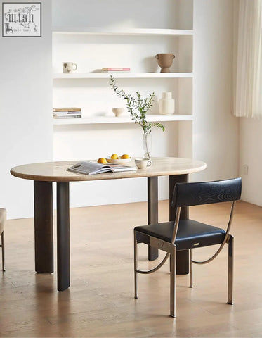 Modern oval dining table with light travertin wood top and dark metal legs perfect for stylish oval dining spaces