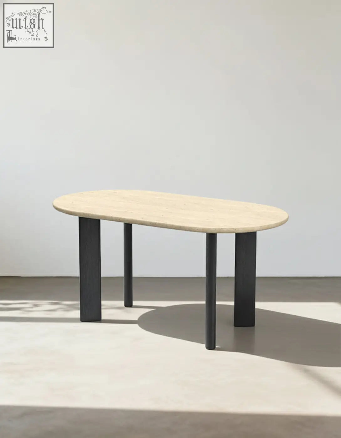 Modern oval dining table with light beige travertine stone top and sleek black metal legs for stylish oval dining