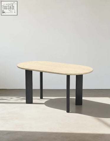 Modern oval dining table with light beige travertine stone top and sleek black metal legs for stylish oval dining