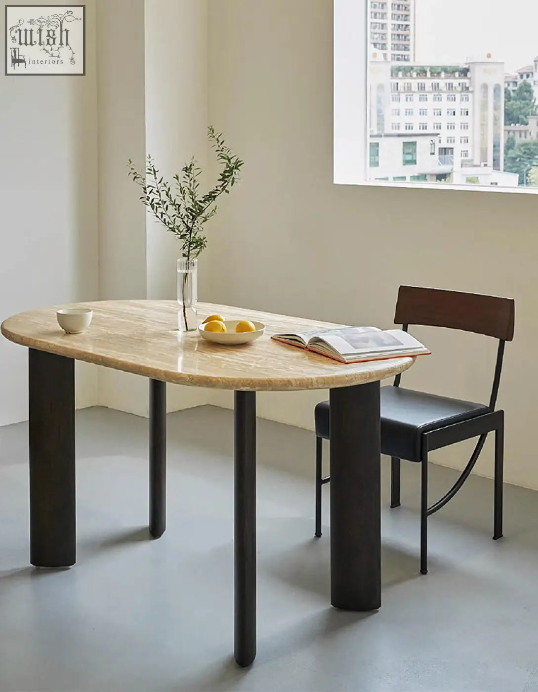 Modern oval dining table with warm beige travertin marble top and sleek black solid wood legs perfect for oval dining